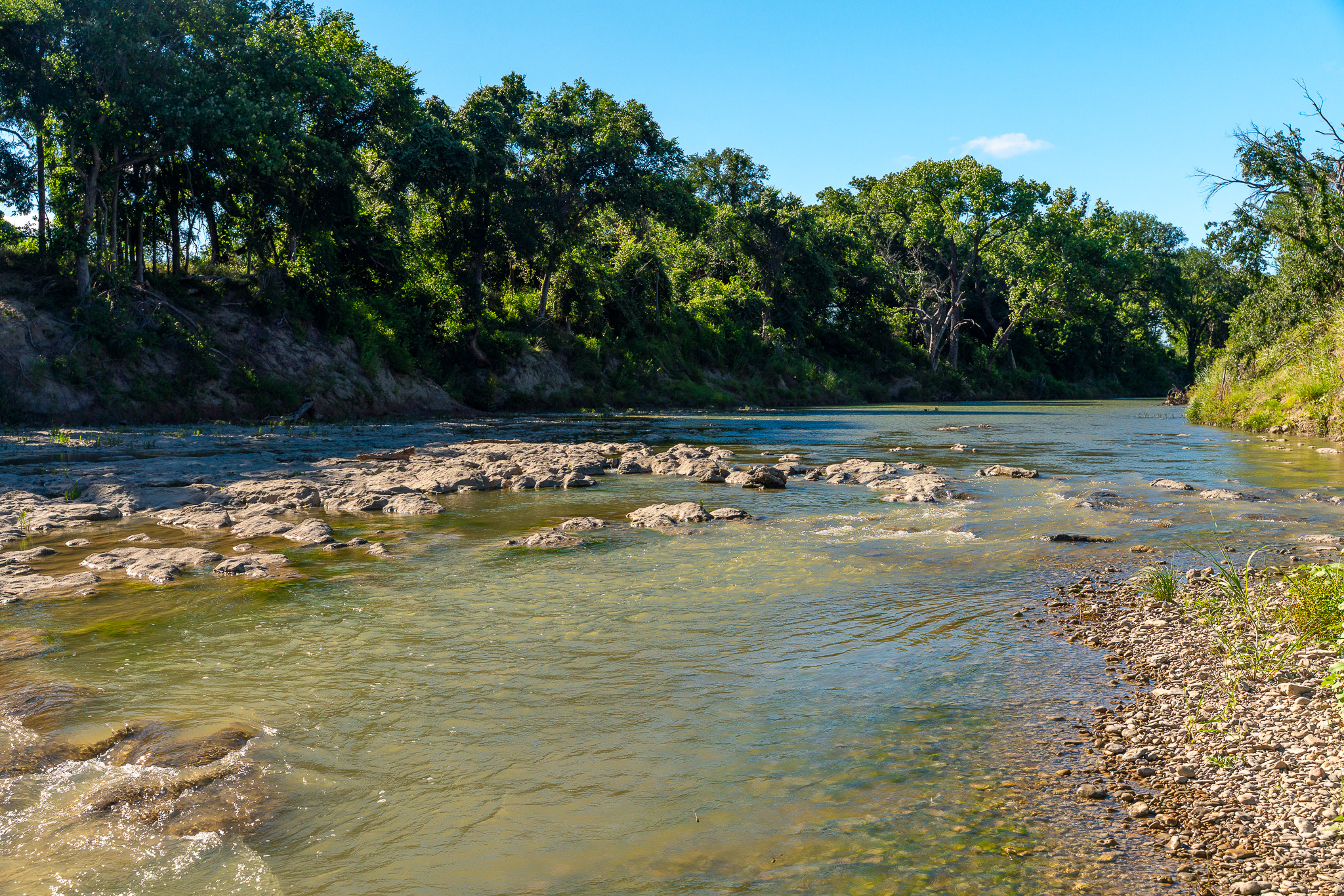 8044 580th Street East Kempner, TX 76539 - Photo 31 of 40 A tranquil river meanders through a lush, tree-lined landscape under a brilliant blue sky.