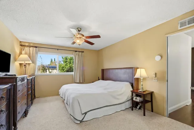 a bedroom with a bed flat screen tv and a large window