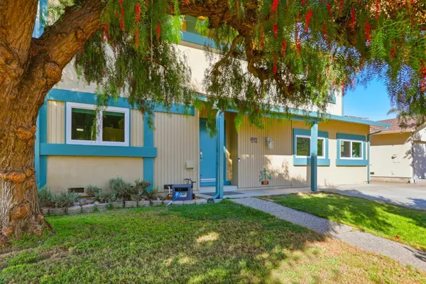 a view of a house with a yard and tree s