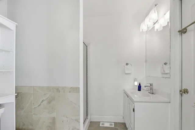 a bathroom with a sink a mirror and shower