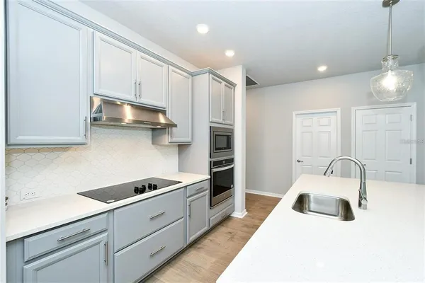 a kitchen with stainless steel appliances granite countertop a sink a stove and a refrigerator