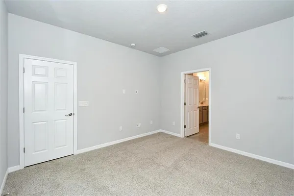 an empty room with closet and a hallway