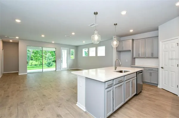 a kitchen with a stove a sink a center island and windows