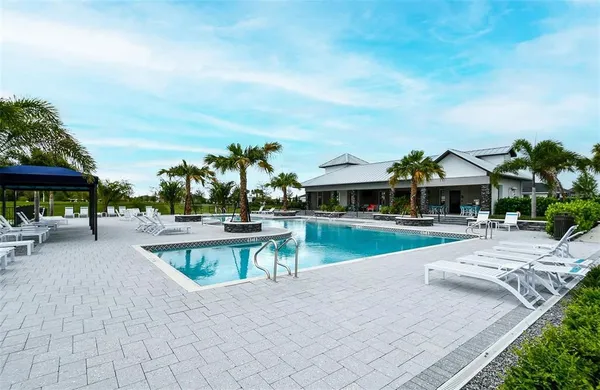 a view of a swimming pool with sitting area and furniture