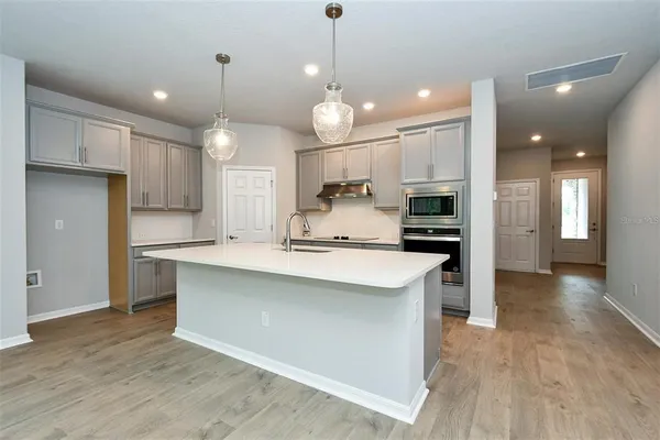 a large kitchen with kitchen island a sink stainless steel appliances and cabinets