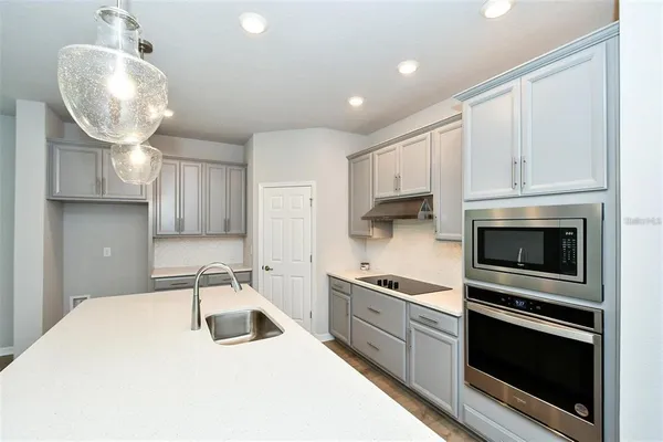 a kitchen with granite countertop a sink stainless steel appliances and cabinets