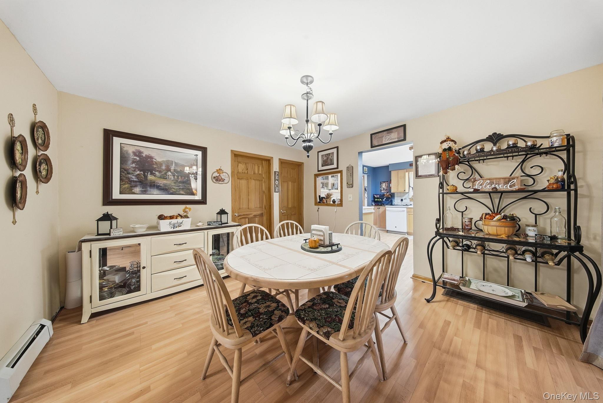 179 Reservoir Road Middletown, NY 10940 - Photo 24 of 50 Dining area featuring a baseboard radiator, light wood-style floors, and a chandelier