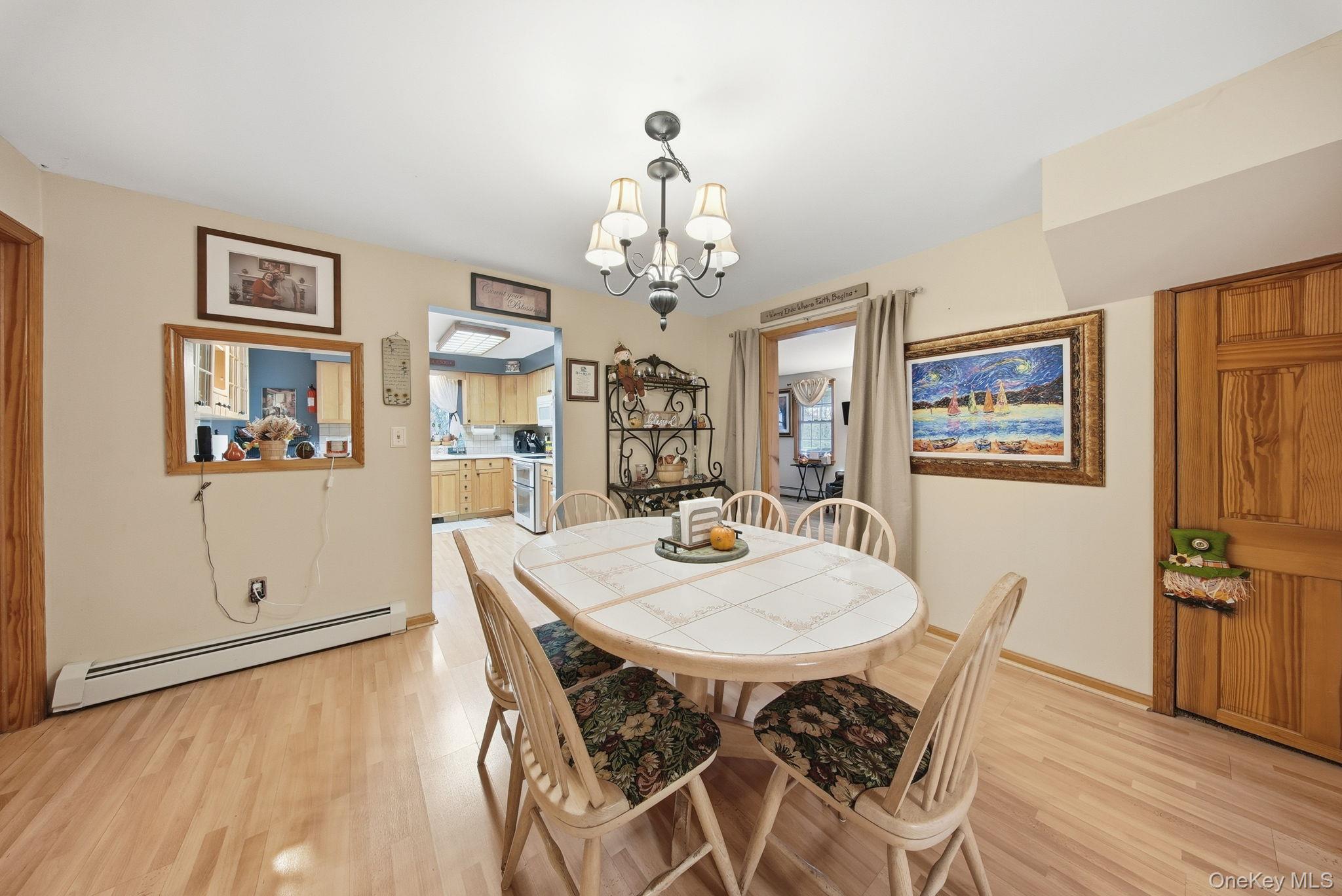 179 Reservoir Road Middletown, NY 10940 - Photo 25 of 50 Dining room with a baseboard heating unit, a chandelier, and light wood finished floors