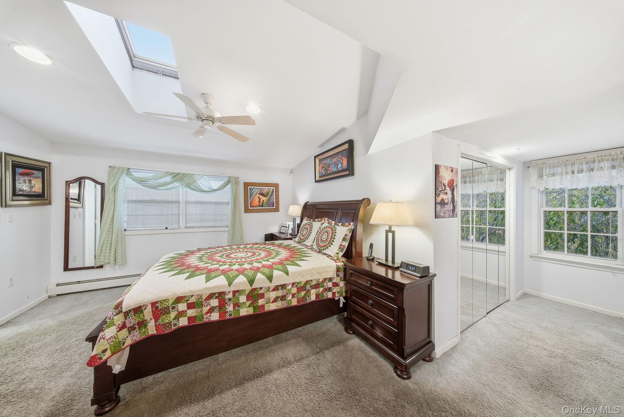 179 Reservoir Road Middletown, NY 10940 - Photo 30 of 50 Carpeted bedroom with a skylight, multiple windows, a baseboard radiator, lofted ceiling, and ceiling fan