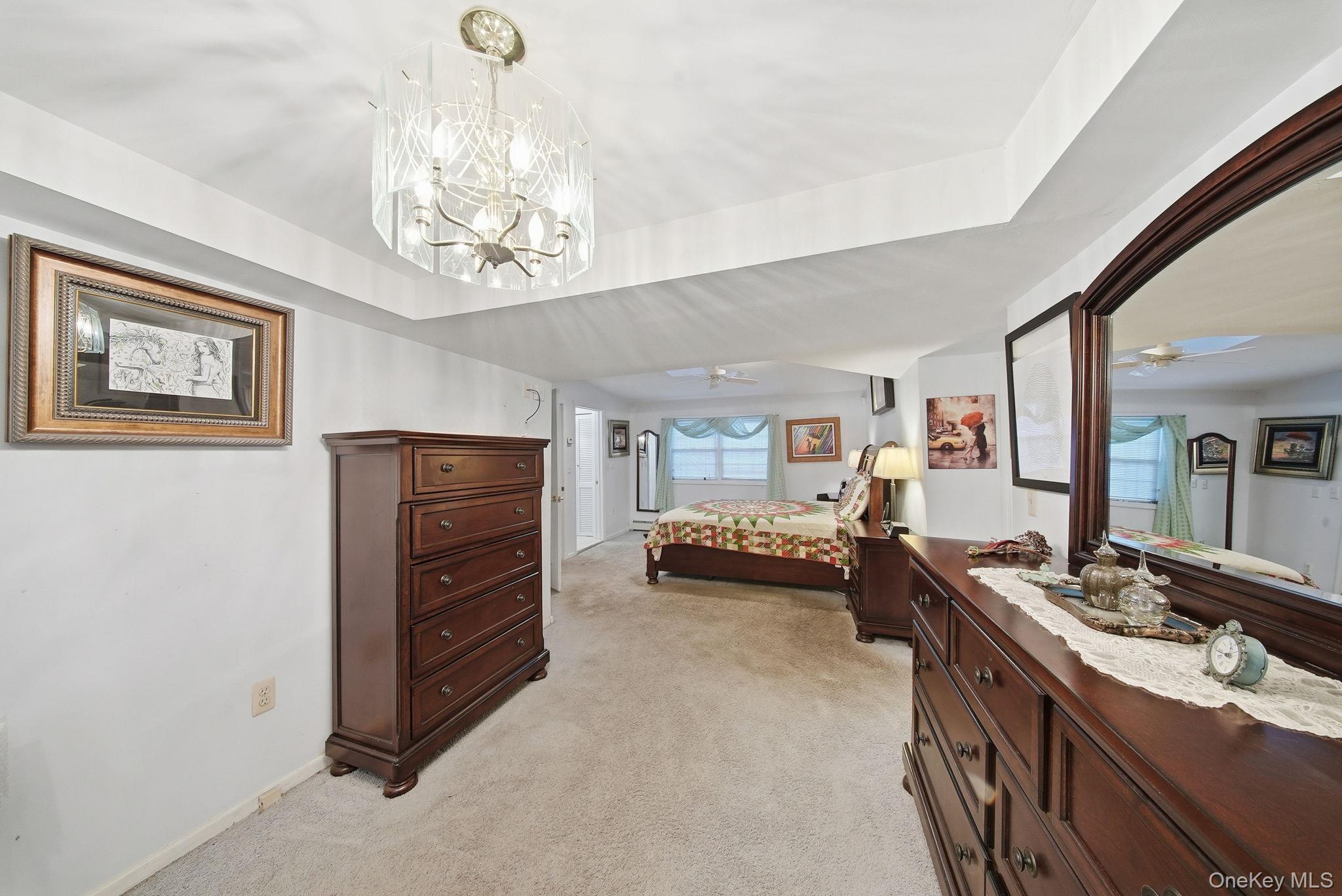 179 Reservoir Road Middletown, NY 10940 - Photo 31 of 50 Bedroom with light colored carpet, a tray ceiling, and a chandelier