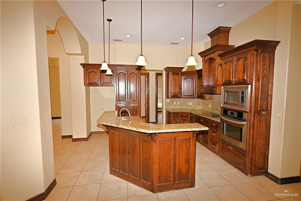7931 Dallas Circle Mission, TX 78574 - Photo 11 of 33 a kitchen with stainless steel appliances granite countertop a sink a refrigerator and a stove