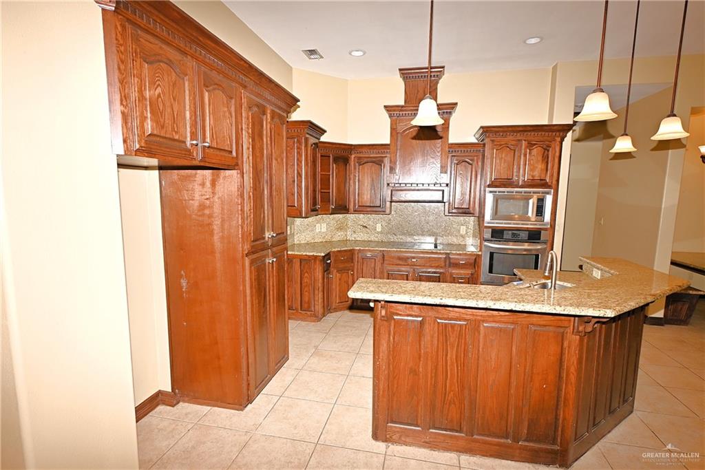 7931 Dallas Circle Mission, TX 78574 - Photo 12 of 33 a kitchen with stainless steel appliances granite countertop a sink and a refrigerator