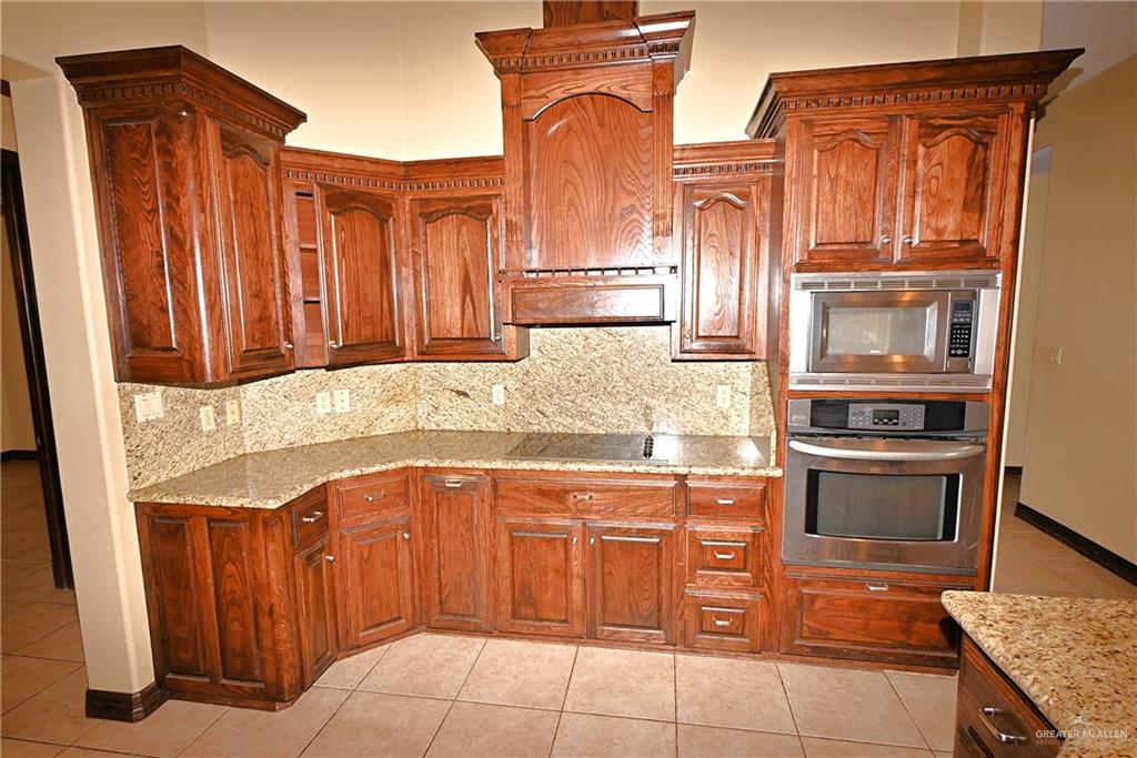 7931 Dallas Circle Mission, TX 78574 - Photo 13 of 33 a kitchen with stainless steel appliances granite countertop a refrigerator and stove