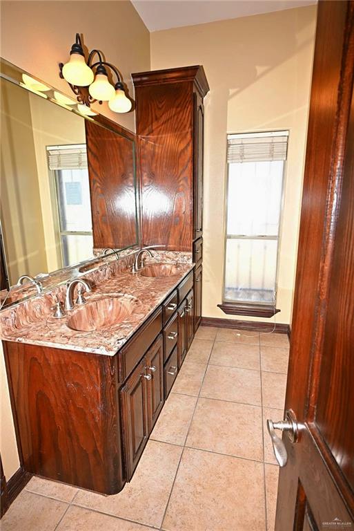 7931 Dallas Circle Mission, TX 78574 - Photo 31 of 33 a bathroom with a granite countertop sink a mirror and a shower