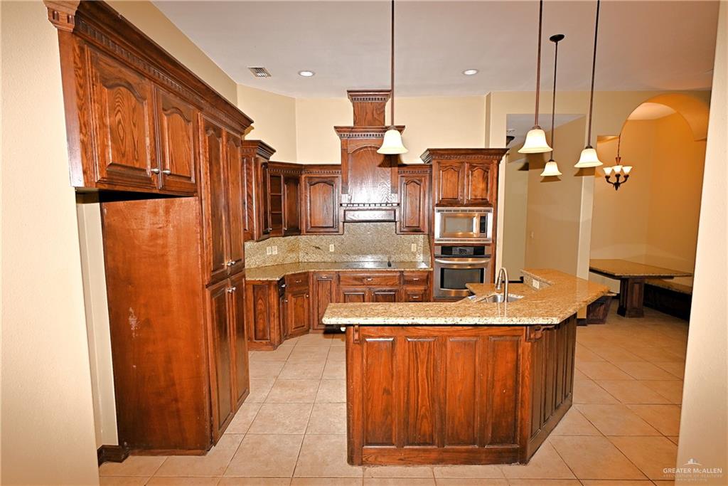 7931 Dallas Circle Mission, TX 78574 - Photo 9 of 33 a kitchen with stainless steel appliances granite countertop a refrigerator a sink and a stove