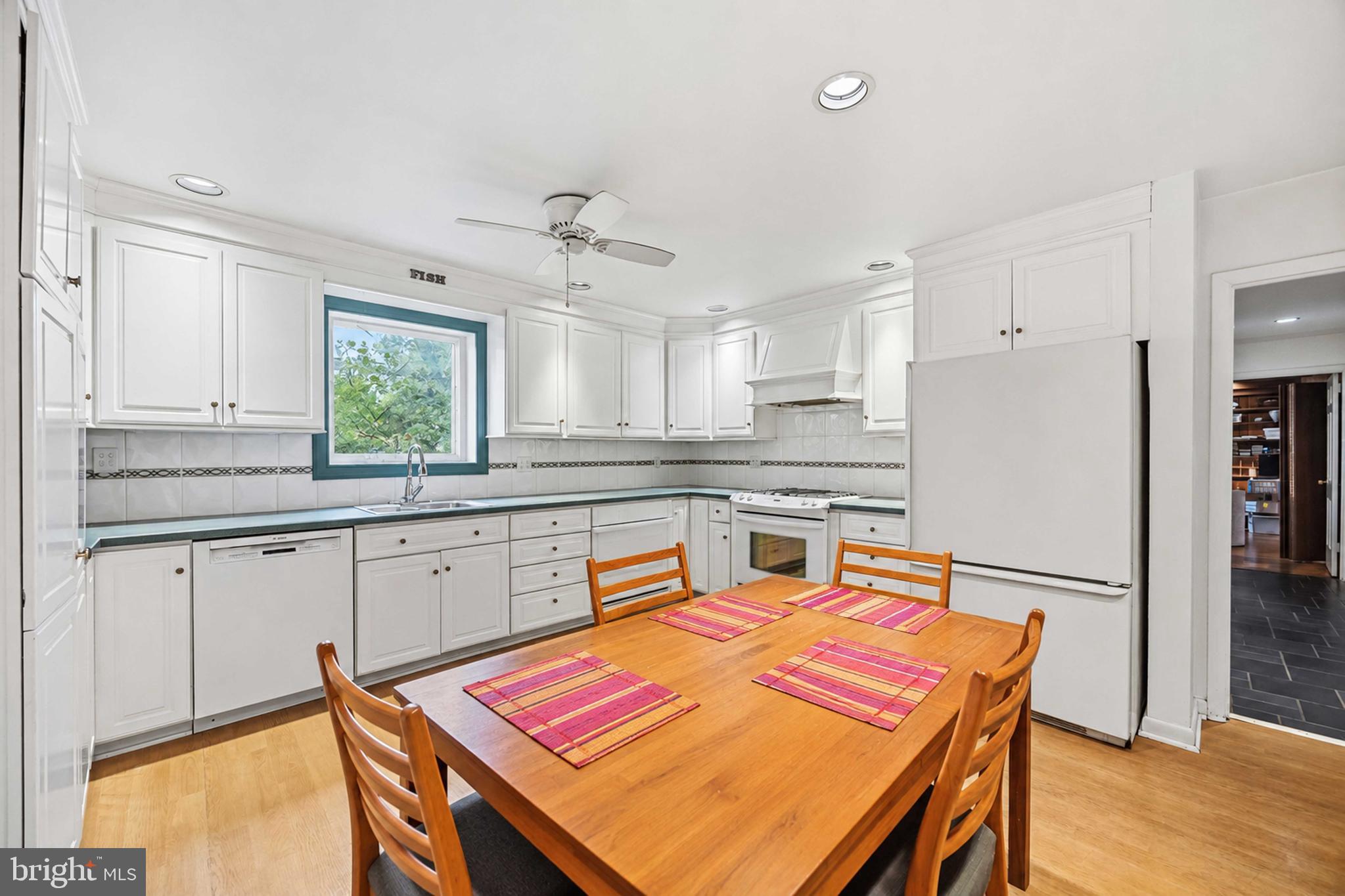 330 Bent Road Wyncote, PA 19095 - Photo 13 of 47 a kitchen with stainless steel appliances sink stove refrigerator and white cabinets with wooden floor