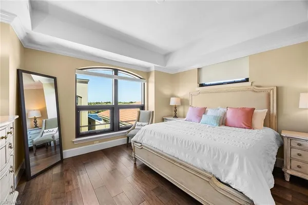 a bedroom with a balcony a bed and a large window