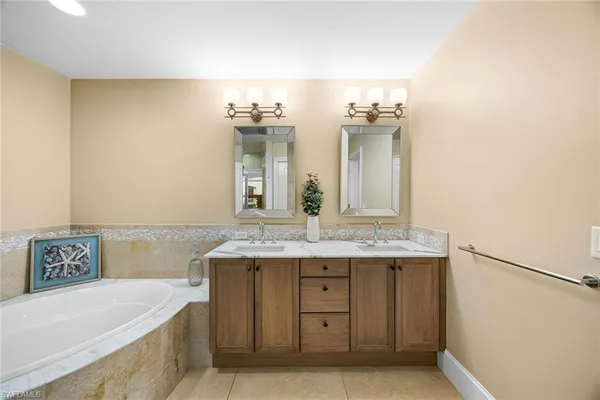 a bathroom with a tub sink and mirror