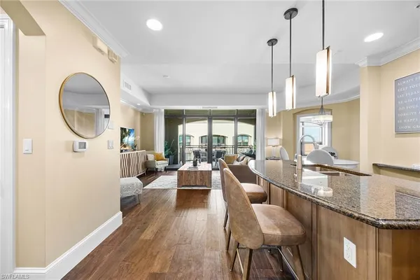 a living room with furniture wooden floor and a large window