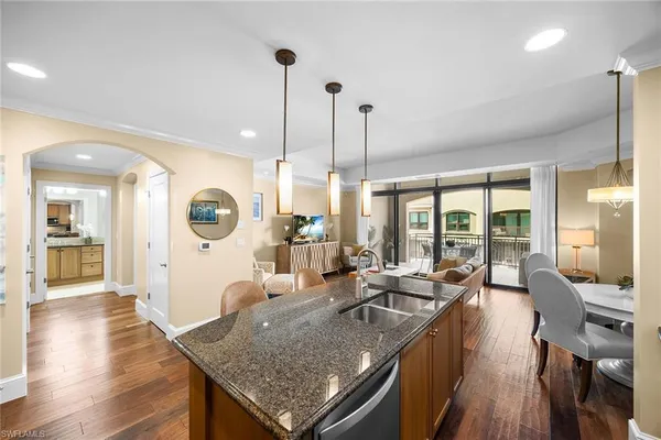 a living room with furniture a large window and wooden floor
