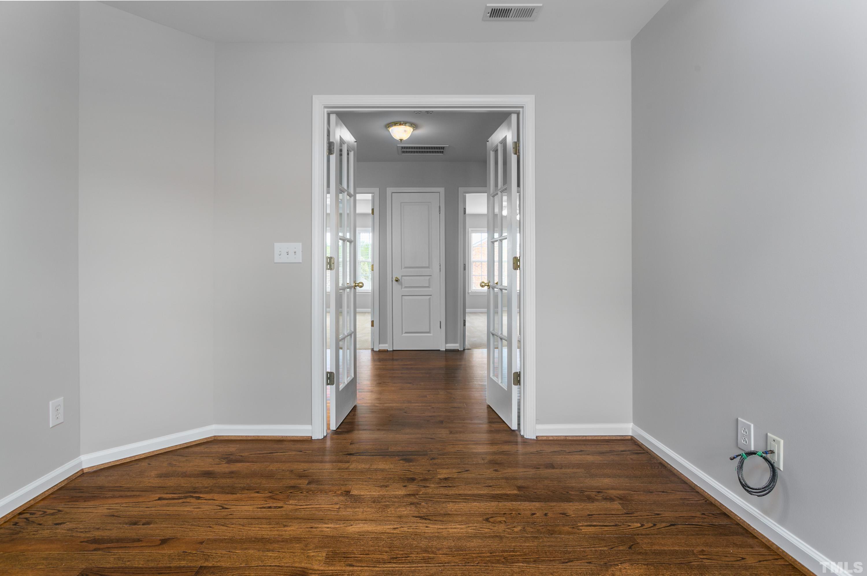 3620 Lion Ridge Court Raleigh, NC 27612 - Photo 23 of 23 a view of an empty room with wooden floor and a mirror