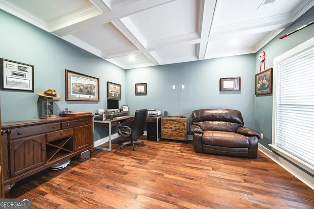 a living room with furniture wooden floor and a large window