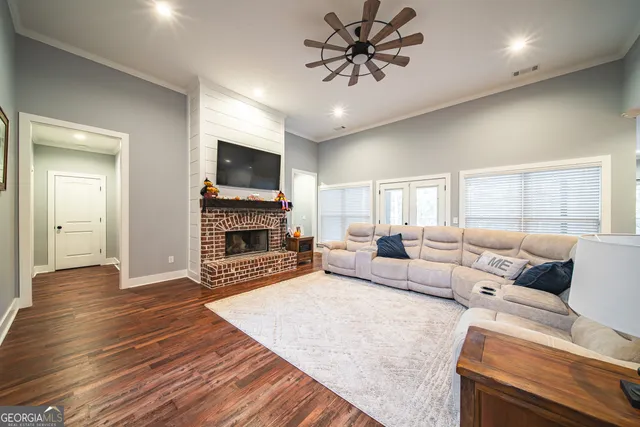 a kitchen with stainless steel appliances kitchen island granite countertop a wooden floors and white cabinets
