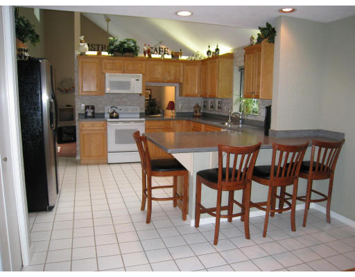 179 Harper Ridge Road Hampstead, NH 03826 - Photo 7 of 26 a dining area with a table chairs and a kitchen view