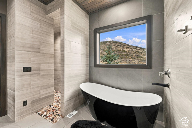 5936 Triple Crown Trail Oakley, UT 84055 - Photo 17 of 57 Freestanding black and white soaking tub, wall-mounted tub filler, and a large window with natural scenery