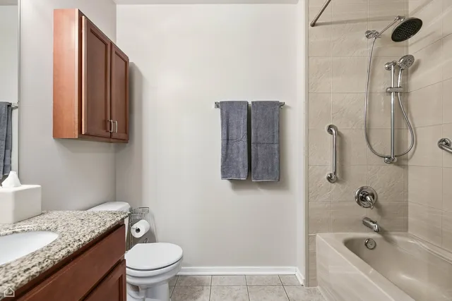 a bathroom with a granite countertop sink a toilet and shower