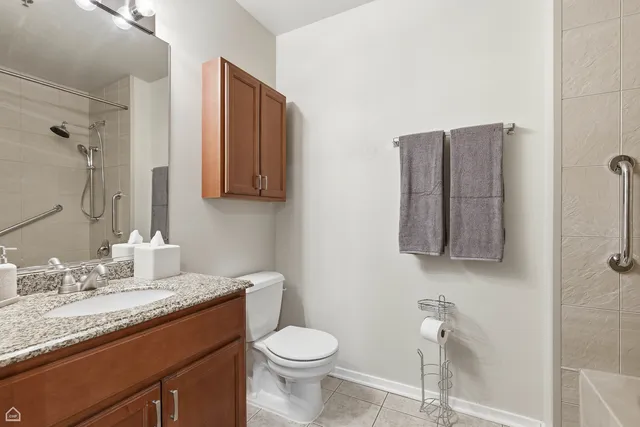 a bathroom with a granite countertop sink toilet and mirror