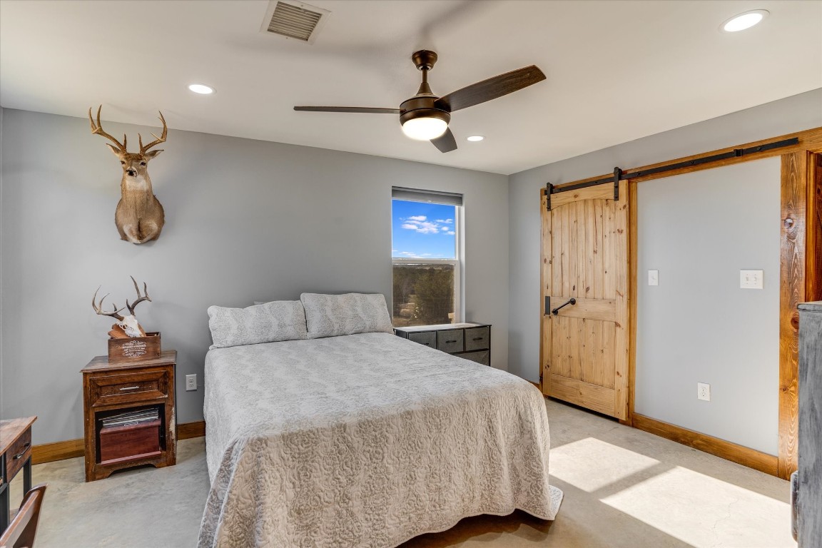5450 County Road 202 Lampasas, TX 76550 - Photo 24 of 35 Bedroom with ceiling fan and a barn door