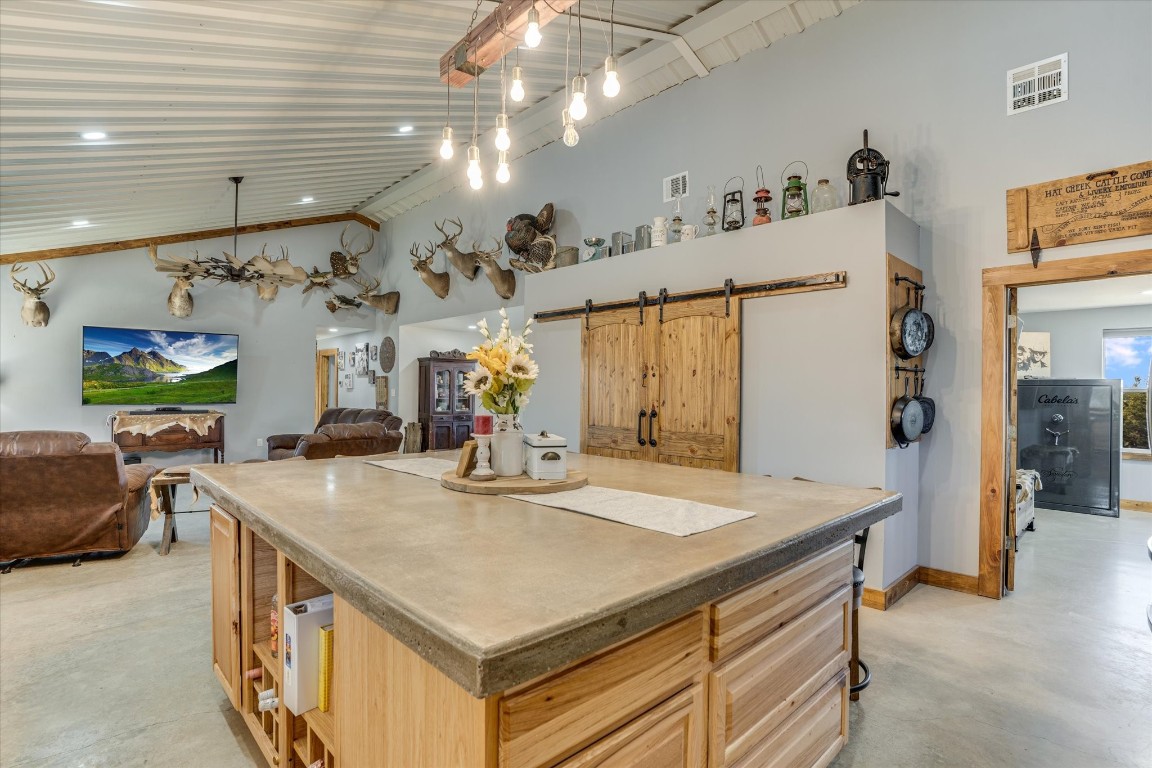 5450 County Road 202 Lampasas, TX 76550 - Photo 10 of 35 Kitchen with light brown cabinetry, pendant lighting, a barn door, and a kitchen island