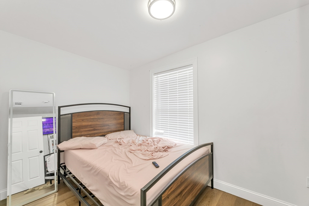 36 Brookledge Street Boston, MA 02121 - Photo 15 of 31 a bedroom with a bed and a mirror