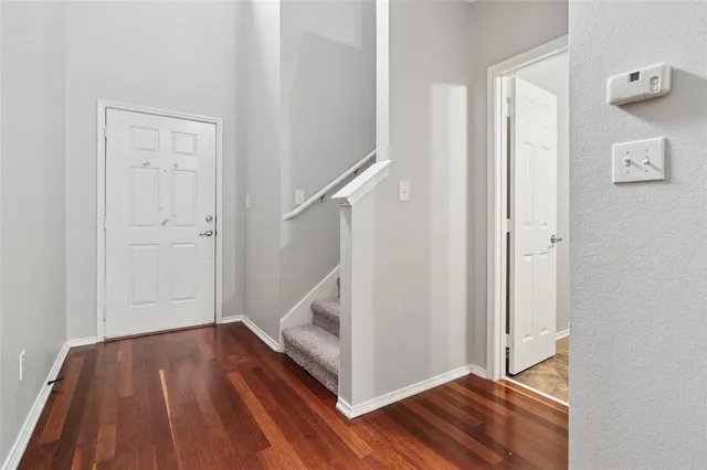 a view of a hallway with wooden floor and entryway