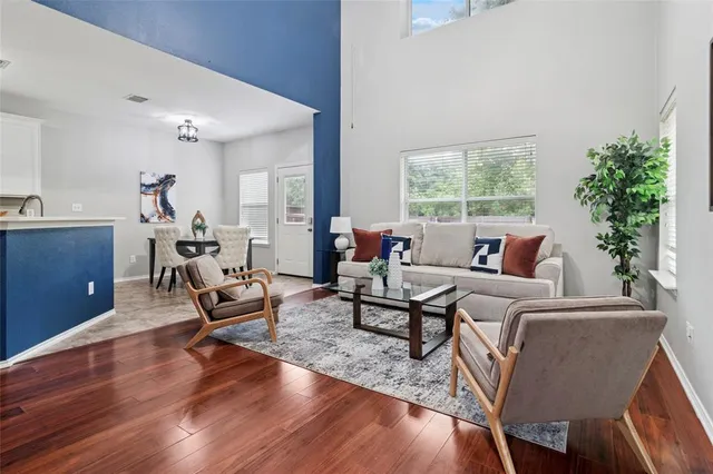 a living room with furniture and a wooden floor