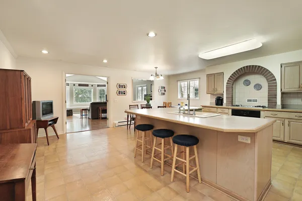 a large kitchen with kitchen island a sink table and chairs