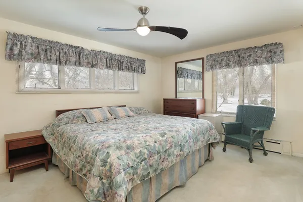 a bedroom with a bed chair and a window
