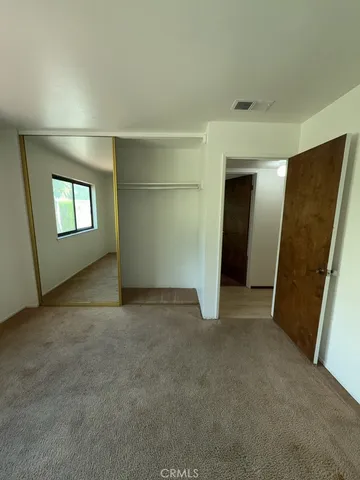 an empty room with windows and closet