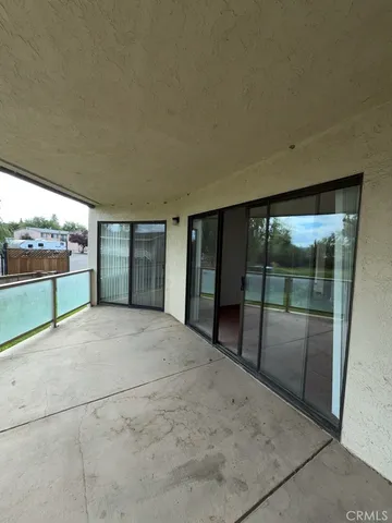 a view of an empty room with wooden floor and a floor to ceiling window