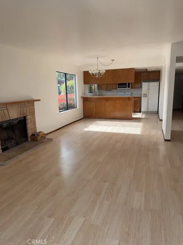 a view of empty room with a fireplace and wooden floor