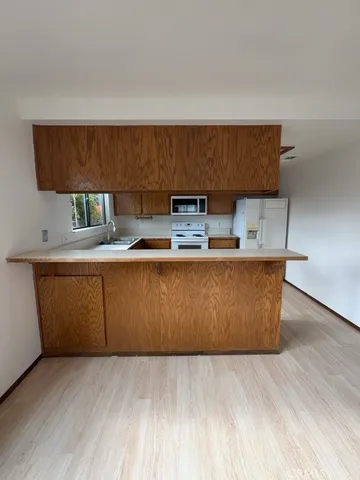 a room with kitchen island a wooden floor and a sink