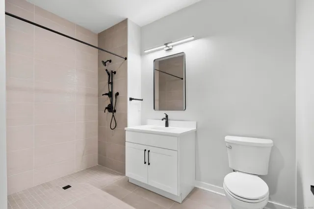 a bathroom with a sink a toilet and shower