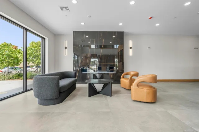 a living room with couches and kitchen view