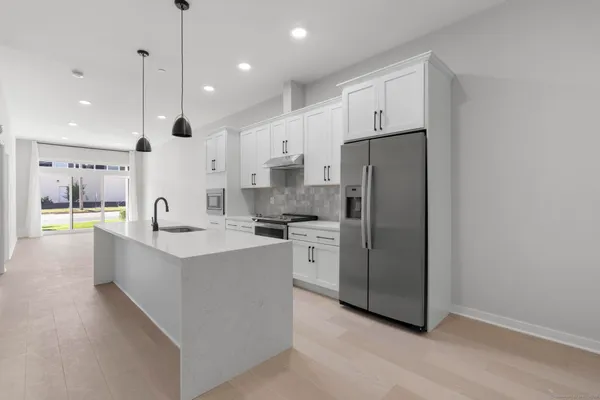 a large kitchen with stainless steel appliances kitchen island granite countertop a sink a stove and a refrigerator