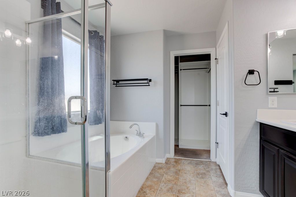 7724 Vibrant Thread Court Las Vegas, NV 89149 - Photo 25 of 43 Indulge in a relaxing soak within this well-appointed bathroom featuring a separate shower and generous soaking tub.