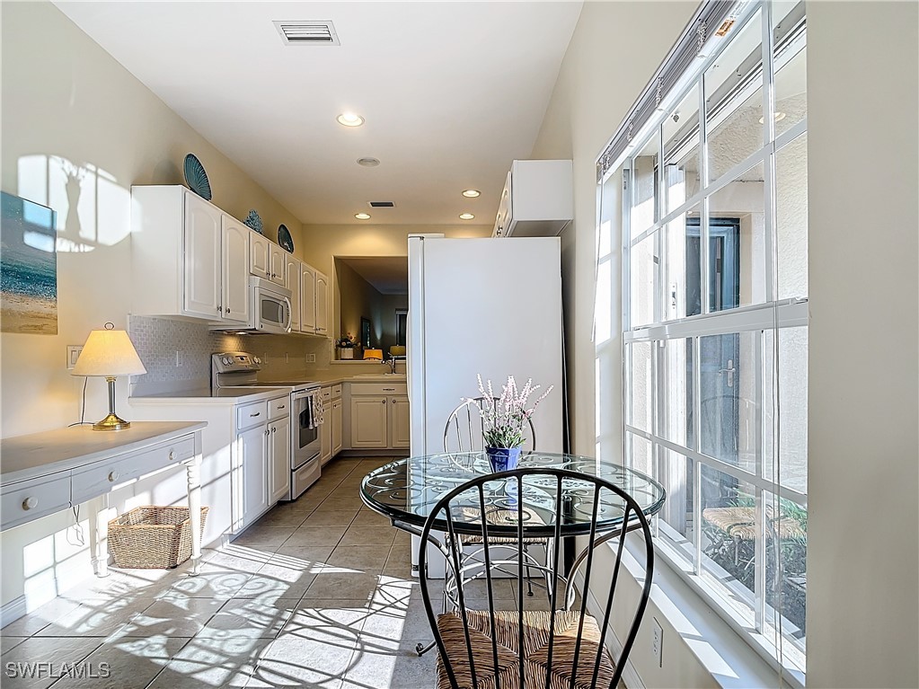 3600 Rue Alec Loop, Unit 4 North Fort Myers, FL 33917 - Photo 12 of 40 a kitchen with stainless steel appliances granite countertop a refrigerator a sink a stove and white cabinets with wooden floor