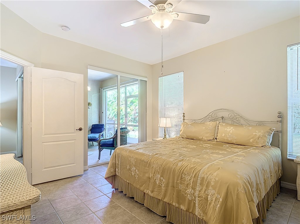 3600 Rue Alec Loop, Unit 4 North Fort Myers, FL 33917 - Photo 19 of 40 a large bed sitting in a bedroom next to a window and a chandelier