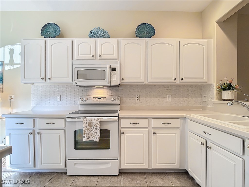 3600 Rue Alec Loop, Unit 4 North Fort Myers, FL 33917 - Photo 8 of 40 a kitchen with white cabinets and white appliances