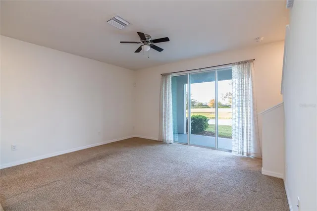 an empty room with a ceiling fan and window